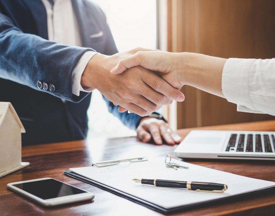 Real estate agent and customers shaking hands together celebrating finished contract after about home insurance and investment loan, handshake and successful deal.